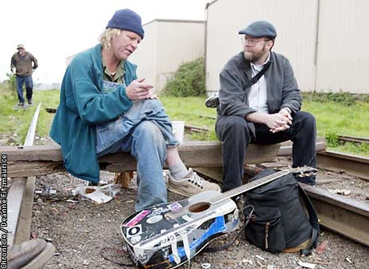 Kevin Hoover, (right) editor and publisher of the Arcata Eye newspaper sits on the railroad tracks on the edge of the town of Arcata and talks with Dan Stephens known as Guitar Dan. Dan and his friends are known as the Fun Bunch in the poetic police blotter that Hoover writes for the weekly newspaper. CHRONICLE PHOTO BY DEANNE FITZMAURICE