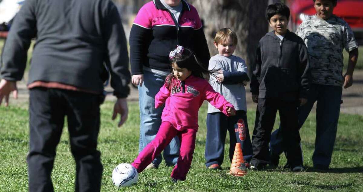 Liz Lopez,5, (ribbon in hair) takes part in a game of kickball Sunday January 29, 2012 at Brakenridge Park with friends and family from Durango Seventh-Day Adventist Church. Church pastor Robin Lopez says the youth group tries out a different park each Sunday. Behind Liz Lopez are (left to right) David Lopez,5, Mel Rey,9, and Gabriel Hernandez,9. John Davenport/San Antonio Express-News