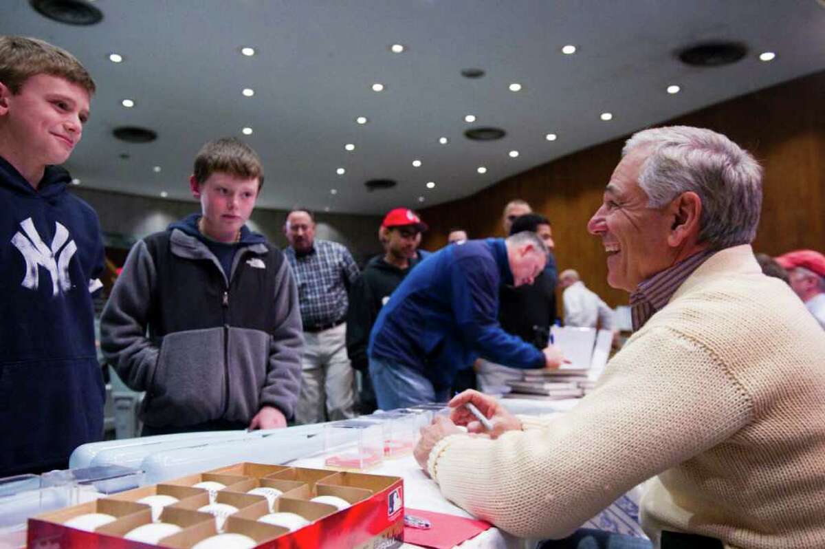 Boston Red Sox Manager Bobby Valentine hassles Yankee fan John Hogan, left, as Mike McLaughlin looks on as Valentine signs memorabilia at his alma mater Rippowam High School in Stamford, Conn., January 29, 2012. Valentine talked baseball with broadcaster Ed Randall in a fundraising event for Randall's charity "Fans for the Cure" aimed at fighting prostate cancer with early detection.
