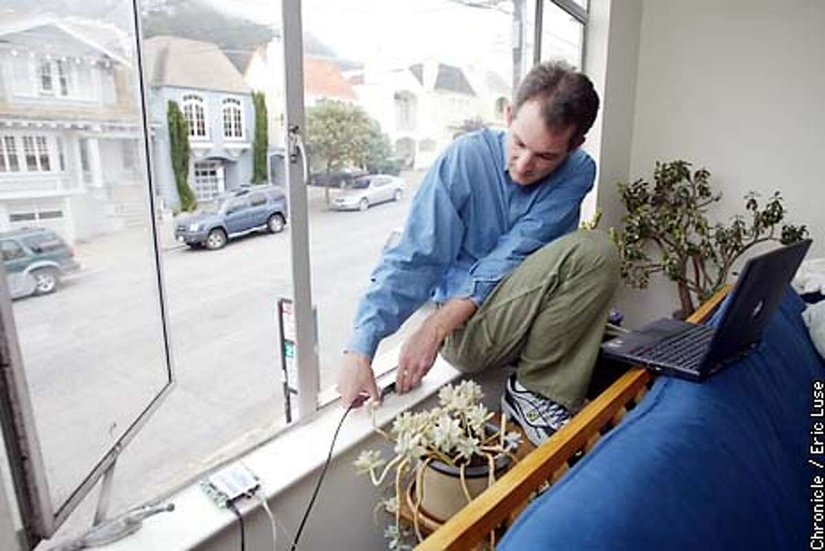 Dan Augustine, co-founder of SF WIreless adjust the antenna of his system that allows users in his neighborhood to access the internet for free. BY ERIC LUSE/THE CHRONICLE
