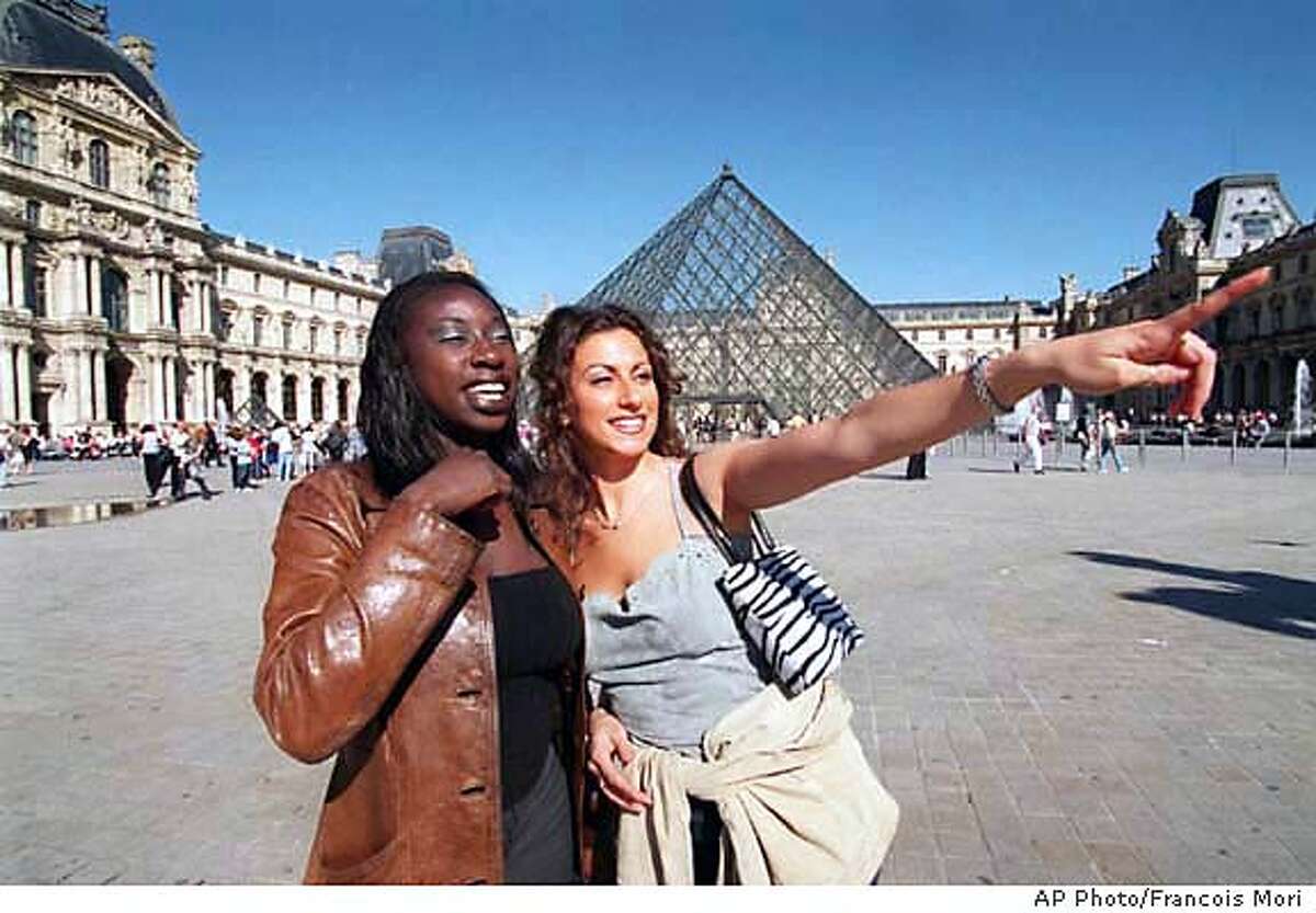 American tourists Diana Keita, from New York, left, and Jill Mottola, from Providence, R.I., in the courtyard of the Louvre museum in Paris Thursday, May 11, 2000. Americans visiting Paris _ and Europe at large _ are hardly unusual. But this year, the old world is far cheaper for holders of U.S. dollars, and more and more Americans are cashing in on European vacations. The European Travel Commission estimates that a record 12 million American tourists will visit Europe this year, spurred by a strong dollar and bargain airfares. That would top 1999's estimated 11.6 million. (AP Photo/Francois Mori)