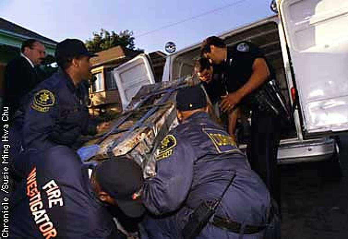 FREEZER/C/15JULY97/MN/SMHC City officials load a freezer containing a body into a coroner's van in Oakland. CHRONICLE PHOTO BY SUSIE MING HWA CHU.