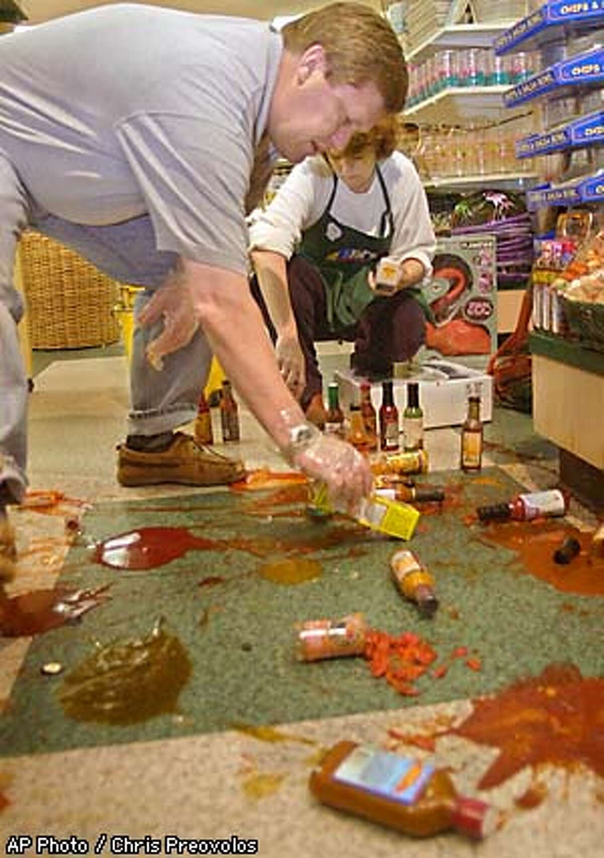 Randy Christensen, left, and his wife, Linda, manager of the Le Gourmet Chef outlet store, in Gilroy, Calif., clean up broken bottles of hot sauce after an earthquake with a preliminary magnitude of 5.2 struck, Monday, May 13, 2002. The U.S. Geological Service reported that the quake struck at 10 p.m. and was centered 3 miles southwest of Gilroy, outside San Jose. No injuries or significant damage was reported. (AP Photo / Chris Preovolos)