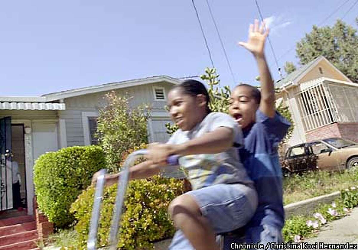 CHRISTINA KOCI HERNANDEZ/CHRONICLE In front of her Laurel District home, in Oakland, (driving bike) Britni Black, age 11, and cousin, Joedy Sadler,( of Oakland but doesn't live in the Laurel), age 9, enjoy a ride down the hills of the neighborhood. Looking at Oakland's Laurel district in regards to race and ethnicity.