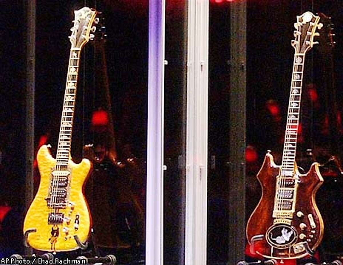 Guernsey's auctioneer Joanne Grant conducts bidding on guitars previously owned by the late Jerry Garcia during an auction Wednesday, May, 8, 2002, at Studio 54 in New York. The guitar named "Wolf," left, sold for $700,000 and "Tiger" sold for $850,000. (AP Photo/Chad Rachman)