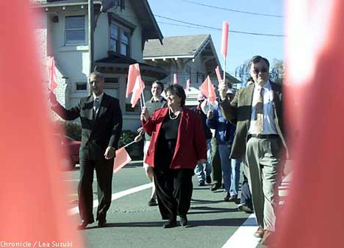 From left: Lee Hightower, Public Works Administration; Councilmember Polly Armstrong; Rene Cardinaux, Dir. Public Works Deparment cross the intersection with their pedestrian flags. BEREKLEY's long awaited experiment to foster pedestrian safety with crosswalk flags began. Pedestrians pick up a flag on one side of the street and carry across the street and leave it on the other side. Photo By Lea Suzuki/San Francisco Chronicle