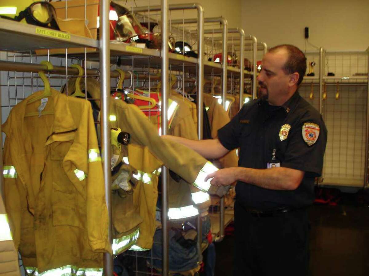 Bexar-Bulverde Volunteer Fire Department Chief Sam Dibrell shows the typical wear on a firefighter’s suit. Suits on average cost $3,000 and have a life of 10 years, but are cleaned only 20 times unless biohazards such as blood or bodily fluids touch the suit. Most suits are smeared with soot and smoke when firefighters head out to duty.