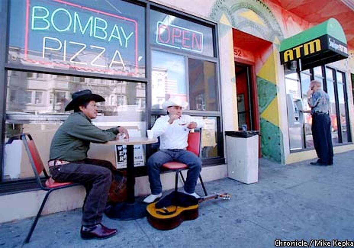 Maximo Juarez and Jacobo Palacios sit outside Bombay Pizza on Valencia. BY MIKE KEPKA/THE CHRONICLE