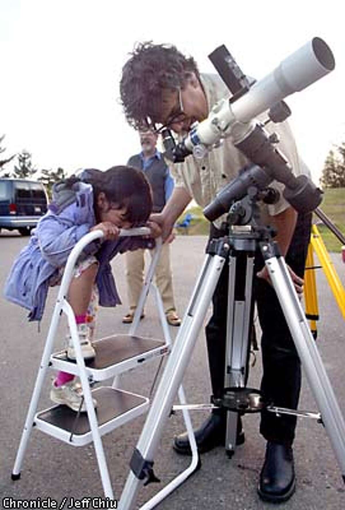 Alex Adams of San Francisco looks through his daughter Ingrid's, 5, Takahashi FC 60mm refractor telescope as Ingrid waits as they and other members of the San Francisco Amatuer Astronomers group prepare for a star party on Mount Tamalpais on Saturday evening. Photo by Jeff Chiu / The Chronicle.