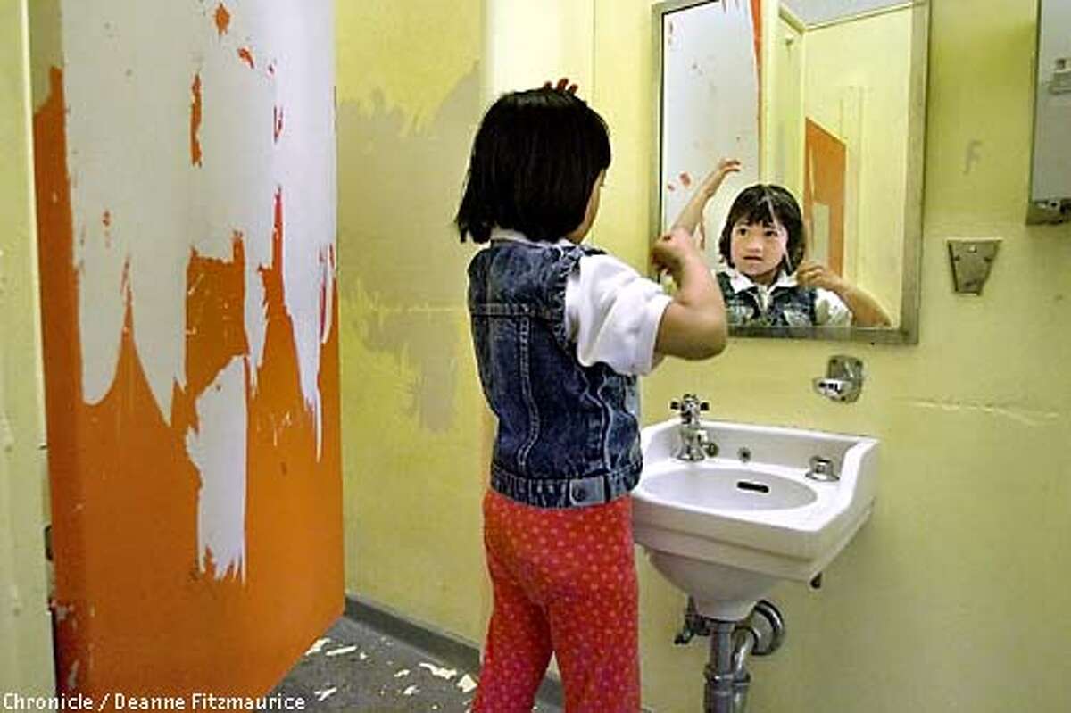SCHOOLS1-C-24SEP01-SN-DF Sara Ramos, a first grader at Bessie Carmichael Elementary School in San Francisco fixes her hair after recess in the girls' restroom which has no soap due to a broken dispenser and is in need of paint and cleaning. CHRONICLE PHOTO BY DEANNE FITZMAURICE