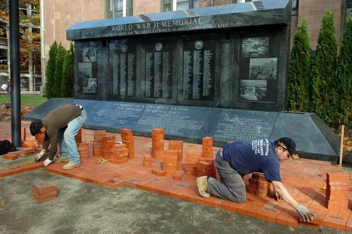 Brothers Alket Meco and Arben Meco work to lay paving bricks near the new World War II Memorial, next to McLevy Hall, in downtown Bridgeport on Nov. 2nd, 2009. The area around the memorial, which was dedicated earlier this year, is being reconfigured in preperation for Veterans Day next week.