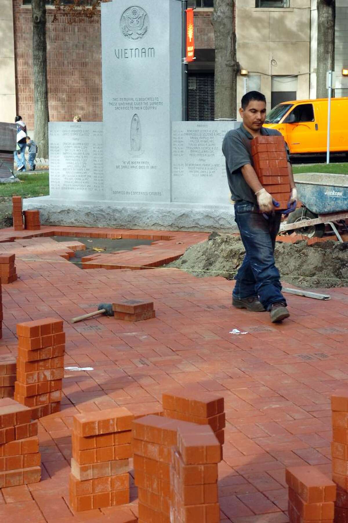 Drian (cq) Cjona carries a pile of bricks near the Vietnam Memorial, next to McLevy Hall, in downtown Bridgeport on Nov. 2nd, 2009. The Vietnam Memorial, which has stood for years, has been moved to a new location next to the recently dedicated World War II memorial.