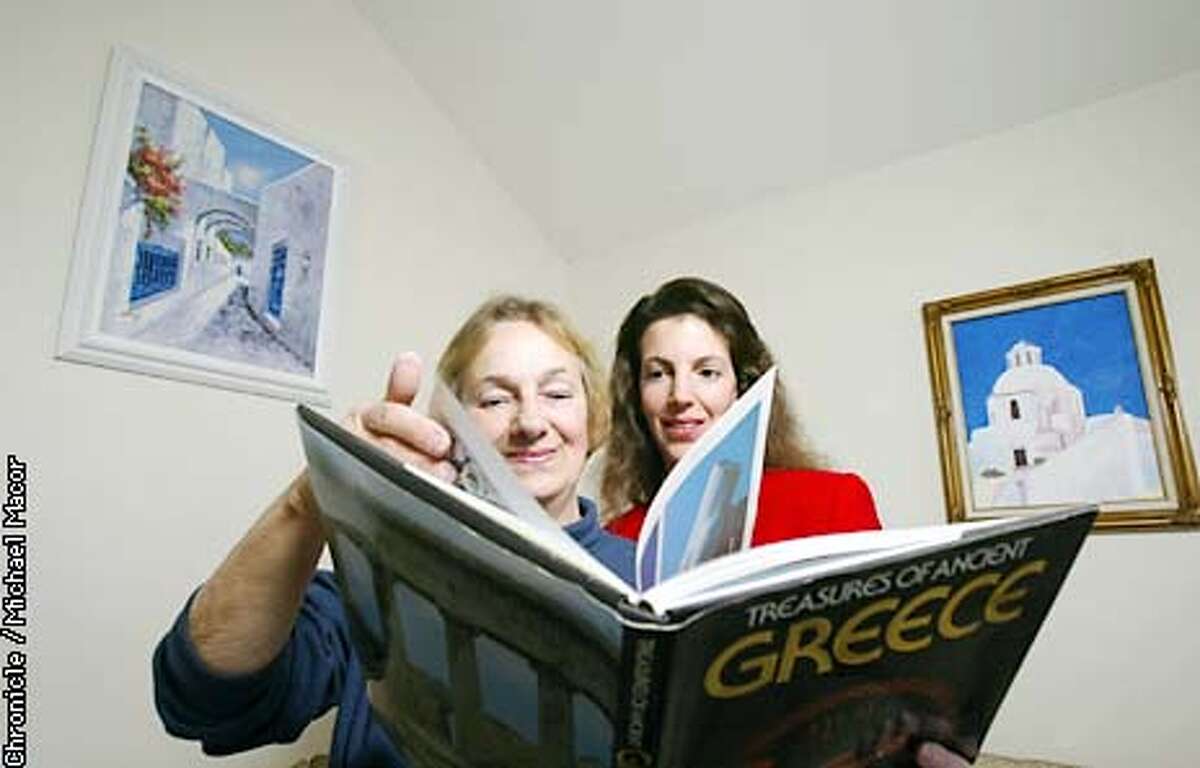 Kay Nicholaw, left, and her daughter Stephani Grant. Grant's parents went to Greece last yearin order to trace their ancestors' roots. The two stand in front of paintings of Greece, left one by a local artist who lives in the hometown of Nicholaw's father and the right is painted by Grant.They now keep in touch with over 20 relatives they recently discovered living the the hometown of Nicholaw's father. by Michael Macor/The Chornicle
