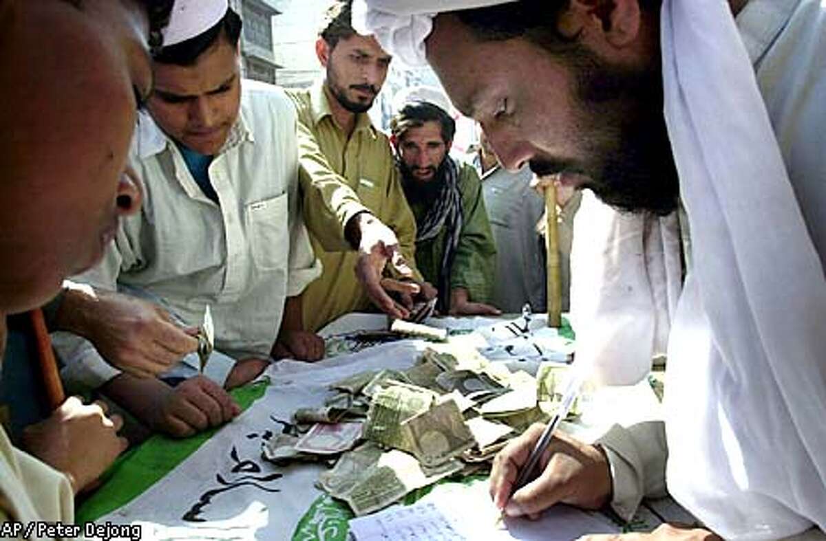 People line up to donate money for the Jihad, or holy war, during a gathering of various political religious and parties in the center of Peshawar, Pakistan, Monday Oct. 15, 2001. Demonstrators shouted anti-U.S. slogans voicing their anger over U.S.-led military attacks in Afghanistan. (AP Photo/Peter Dejong)