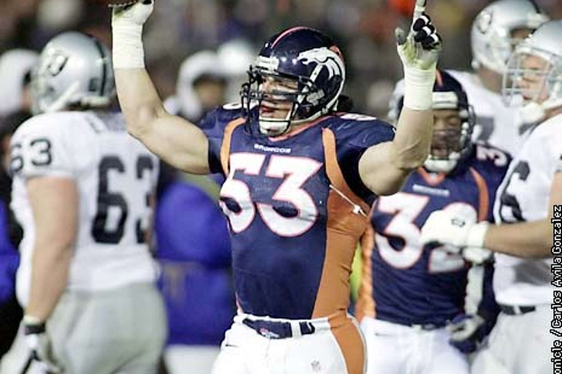 Denver Broncos linebacker Bill Romanowski celebrates after