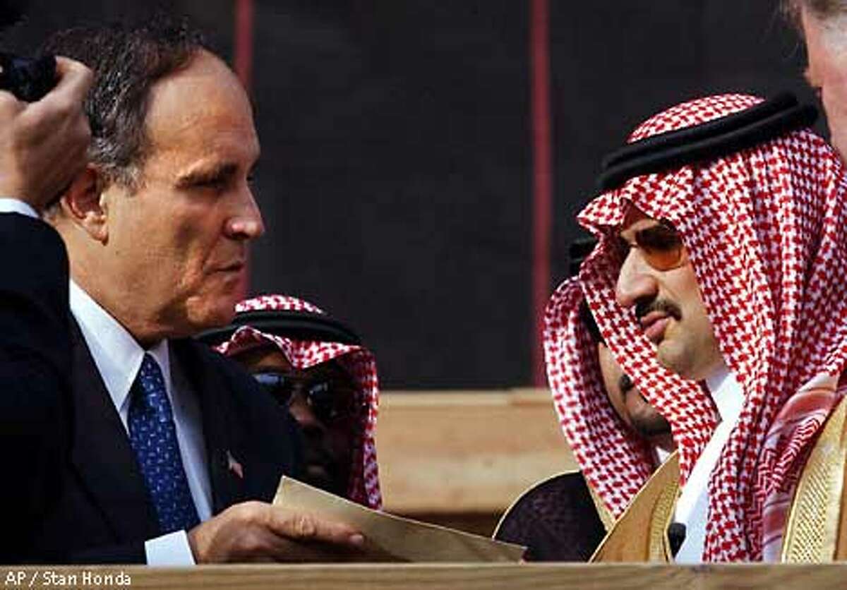 One month after the terrorist attacks on the World Trade Center, Prince Alwaleed Bin Talal of Saudi Arabia, chairman of Kingdom Holding Company, right, hands New York Mayor Rudolph Giuliani, a check for $10 million for relief efforts on Thursday, October 11, 2001, in New York. Prince Alwaleed, a member of the Saudi royal family who was sixth on Forbes magazine's list of the world's richest men for 2001, also visited ground zero. (AP Photo/Stan Honda,pool)