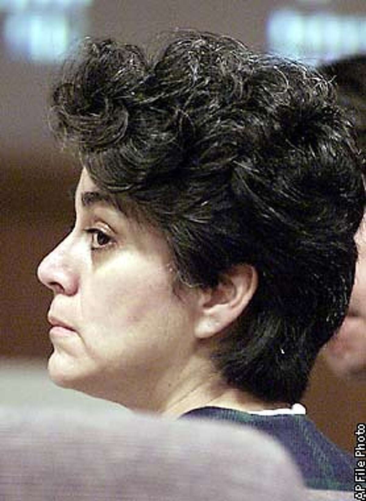 Socorro Caro listens as former Ventura County Medical Examiner Warren Lovell testifies as an expert witness in her murder trial at Ventura County Superior Court, Tuesday, Oct. 2, 2001, in Ventura, Calif. The defense used Lovell's testimony to further their claim that Caro did not shoot herself as the prosecution contends. Caro is accused of killing three of her four children in 1999. (AP Photo/Stephen Osman, Pool)