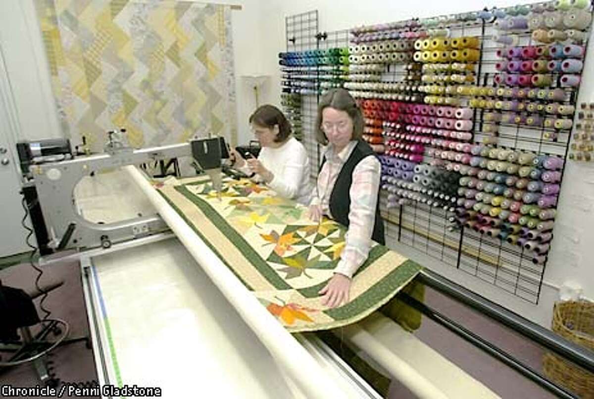 Sally Davey, owner of this store at rt. & Mary Anne Jayhartt at the Quilting machine called a Gammill Longarm. Quilts that take weeks can be sewn in just a few hours with this machine. New Pieces, a quilting store in Albany. CHRONICLE PHOTO BY PENNI GLADSTONE