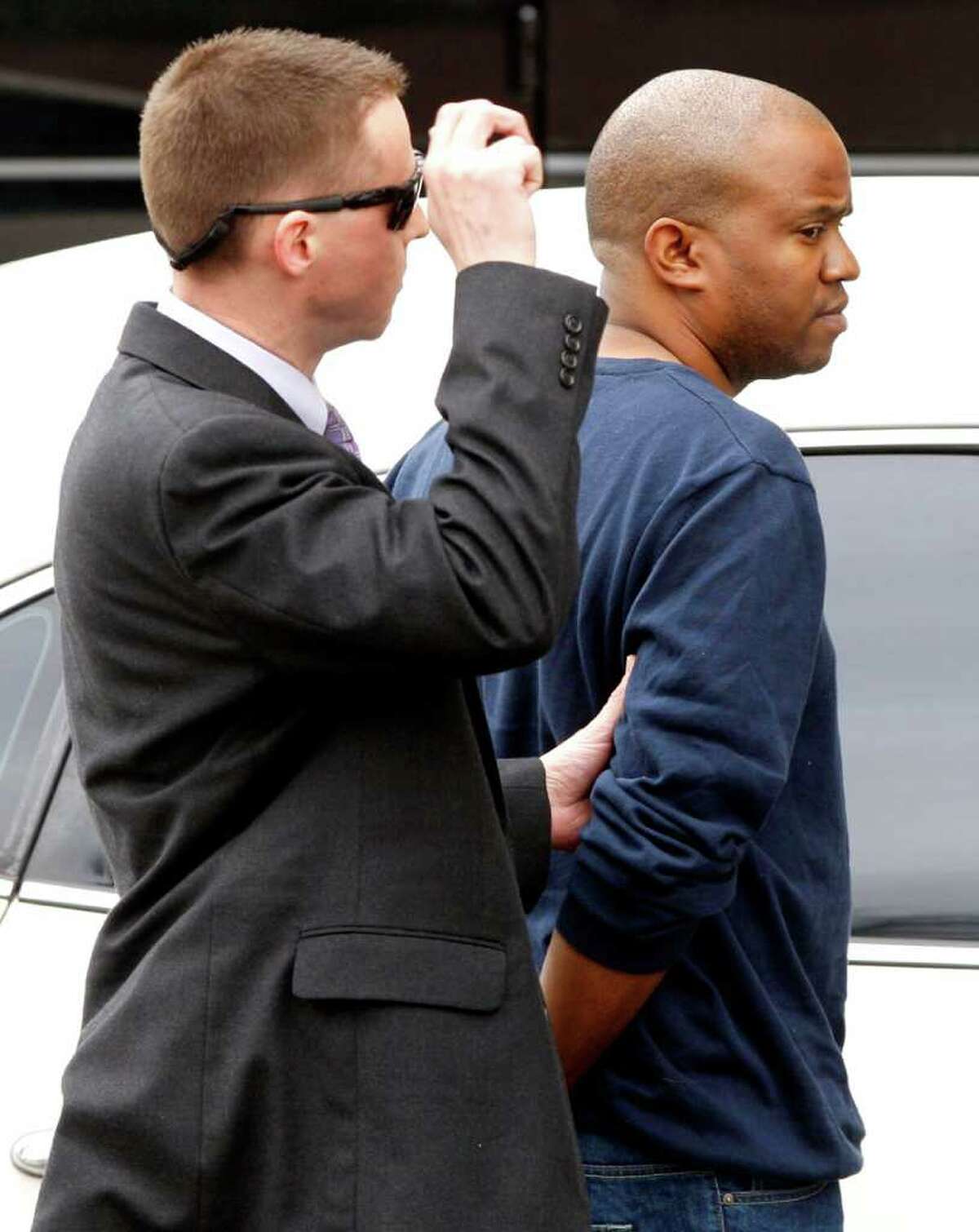 FBI agents take Gemase Lee Simmons (right) to federal court in San Antonio on Jan. 31, 2012, after he was arrested on federal child-porn related charges. Simmons was featured in a news segment on Dateline alleging he scammed several youths into believing they were being filmed for a reality show about modeling.