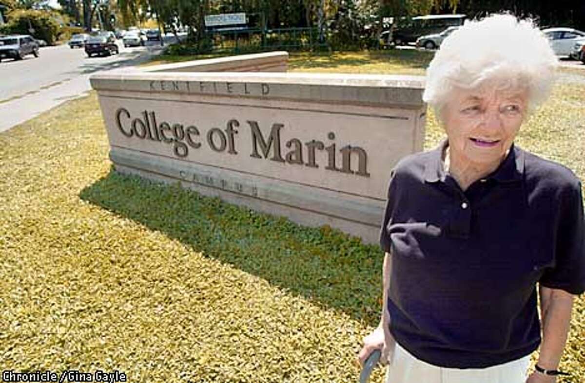Jane Davis, a former and present student at the College of Marin stands near the main sign to the college.