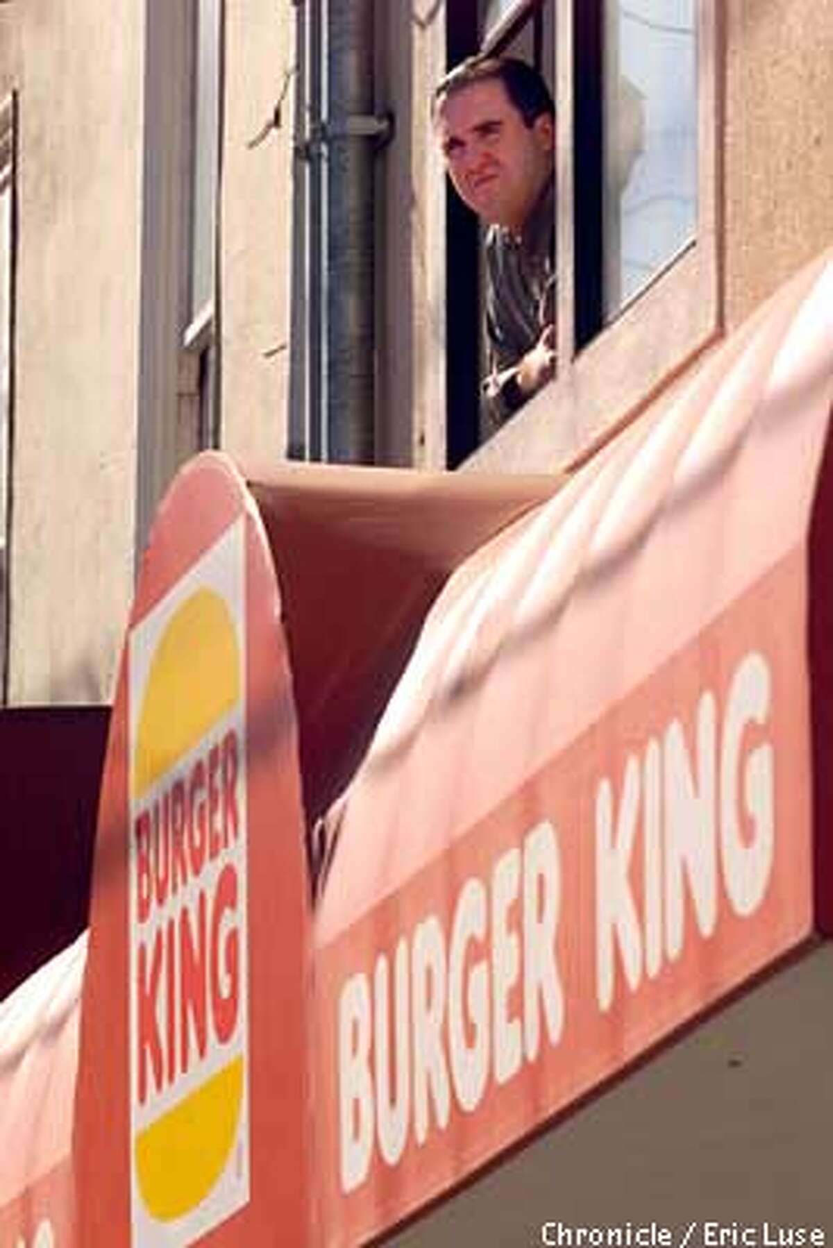 Owne Travers looking out his apartment window on 9th Avenue near Irving where he is directly above Burger King. BY ERIC LUSE/THE CHRONICLE