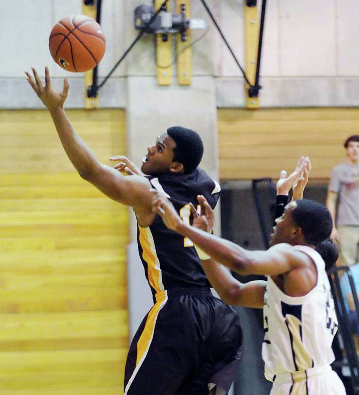 At left, Donqutae Robinson # 14 of Brunswick grabs a rebound while being defended by Darren Douglas # 22 of Rye Country Day School during boys high school baskebtball between Brunswick School and Rye Country Day School, at Brunswick School, Tuesday night, Jan. 31, 2011.
