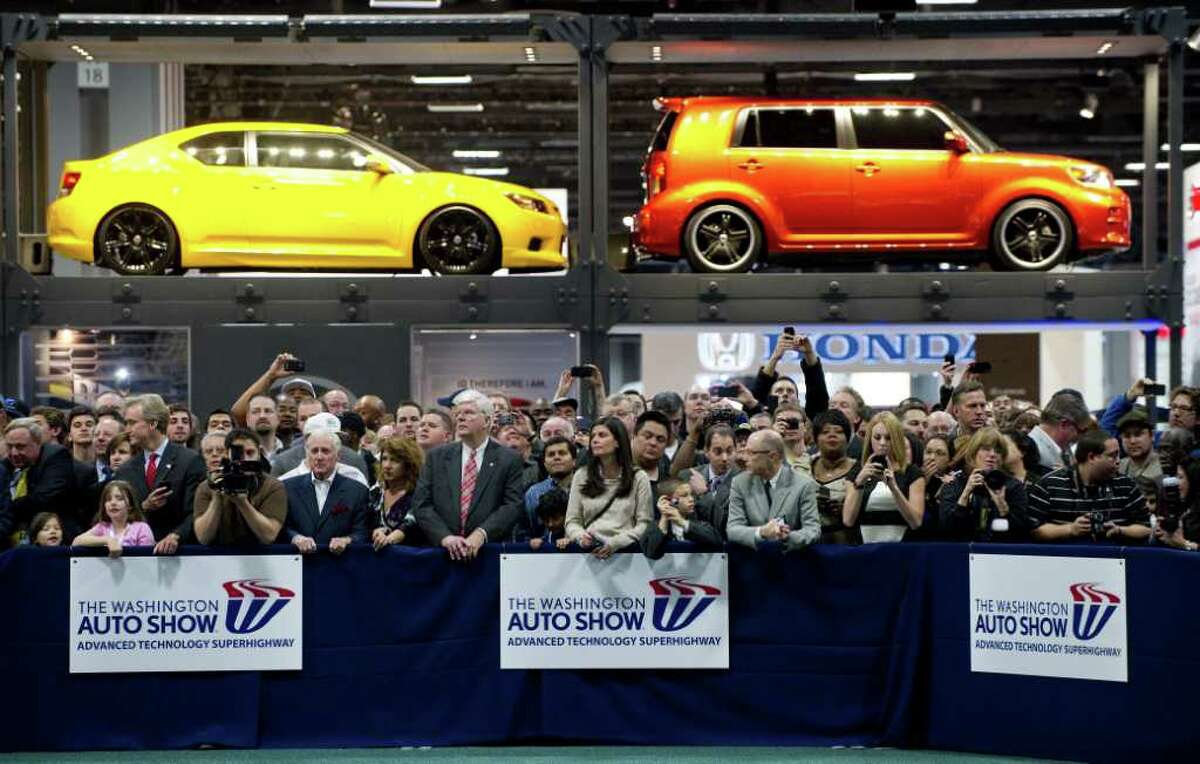 Onlookers watch as US President Barack Obama tours the 2012 Washington Auto Show at the Washington Convention Center in Washington, DC, January 31, 2012.