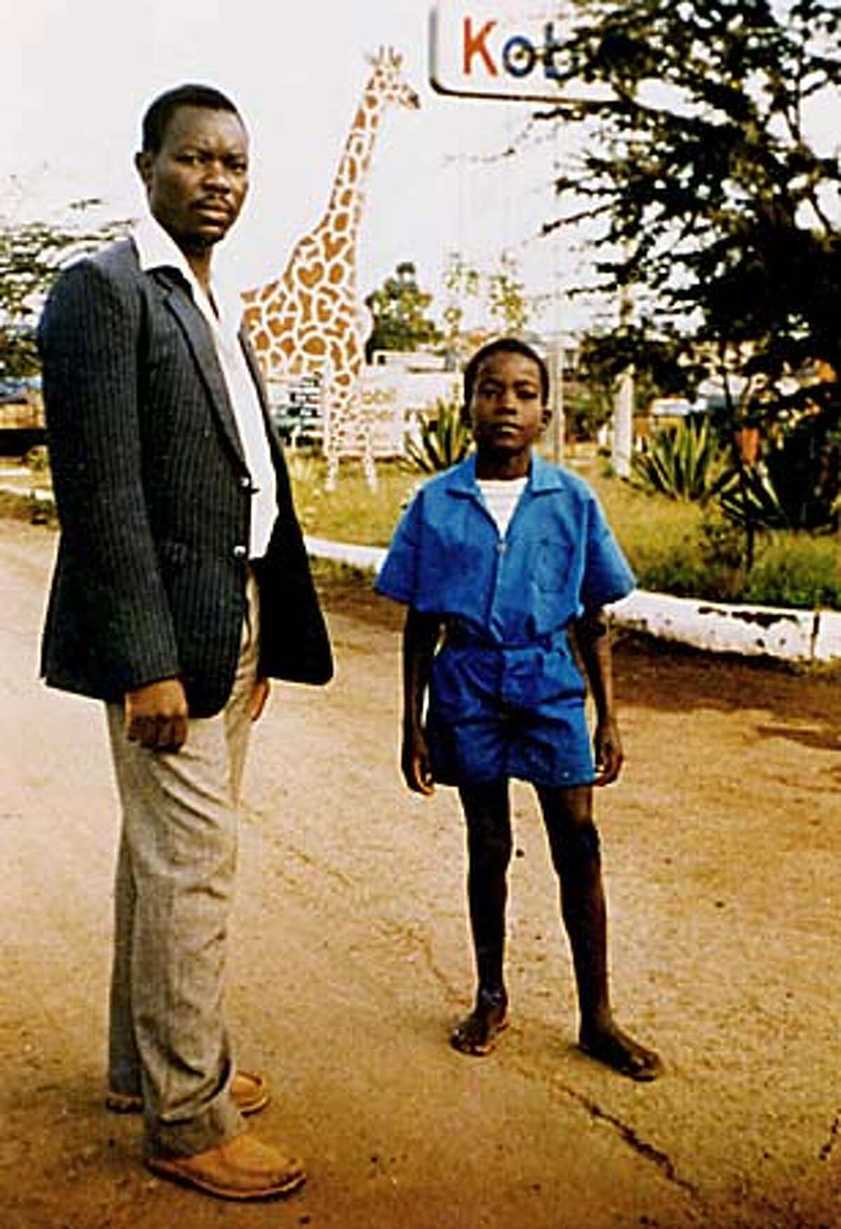 At age 10, Masai student Kimeli Naiyomah posed with his Kenyan primary school teacher S. Nyangeri.