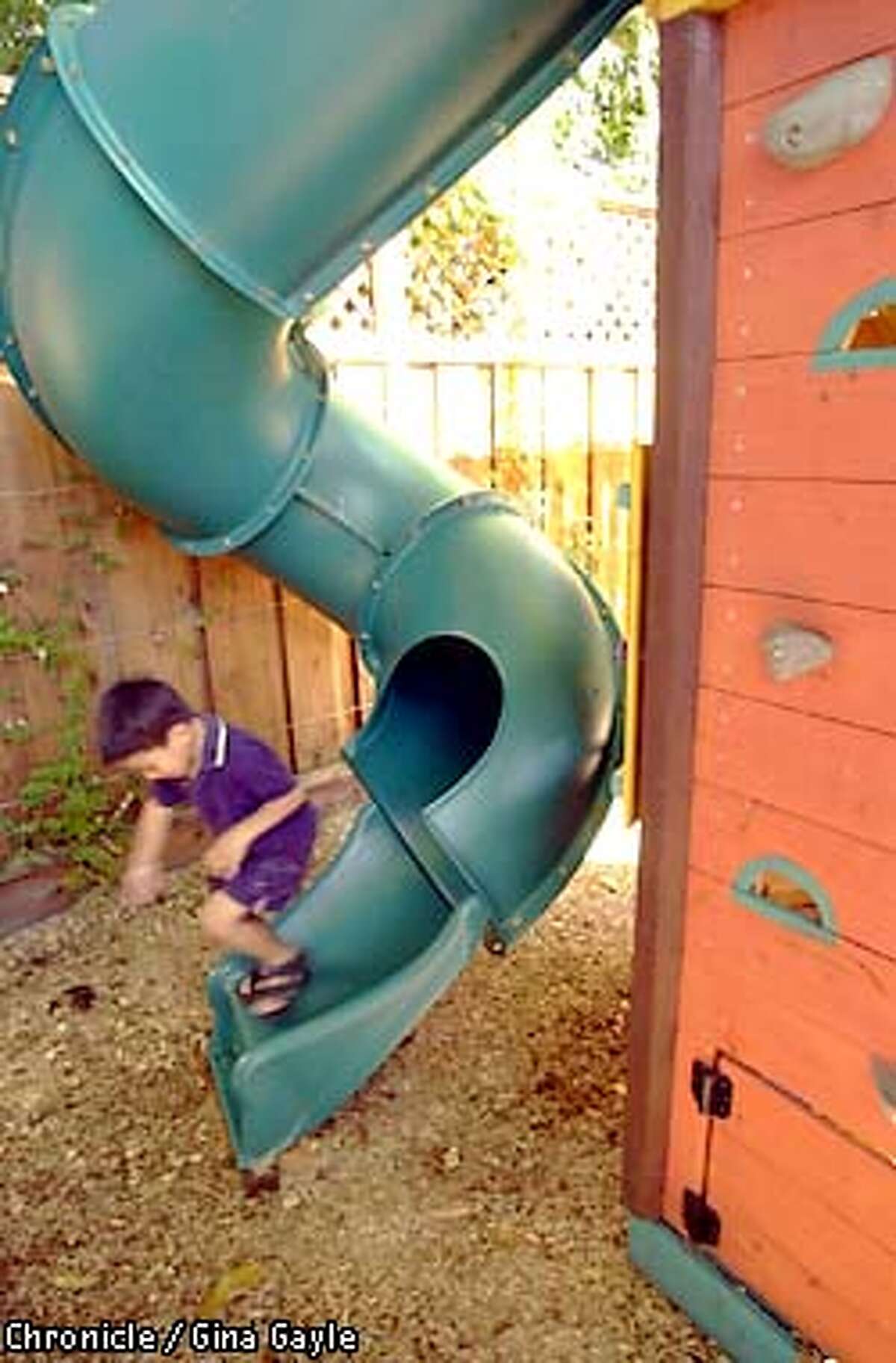 Tanner Bost,5, jumps off the slide of the treehouse in his backyard. Photo by Gina Gayle/The SF Chronicle.