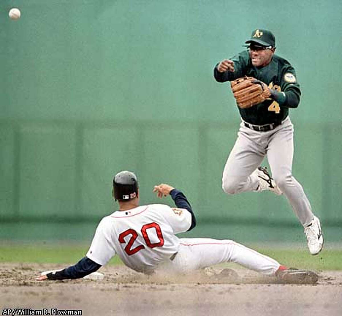 Oakland Athletics' Miguel Tejada fires to first after tagging Boston Red Sox' Darren Lewis to make the double play off a Trot Nixon grounder Sunday, May, 13, 2001, at Fenway Park in Boston. The Red Sox beat the A's 5-4. (AP Photo/William B. Plowman)