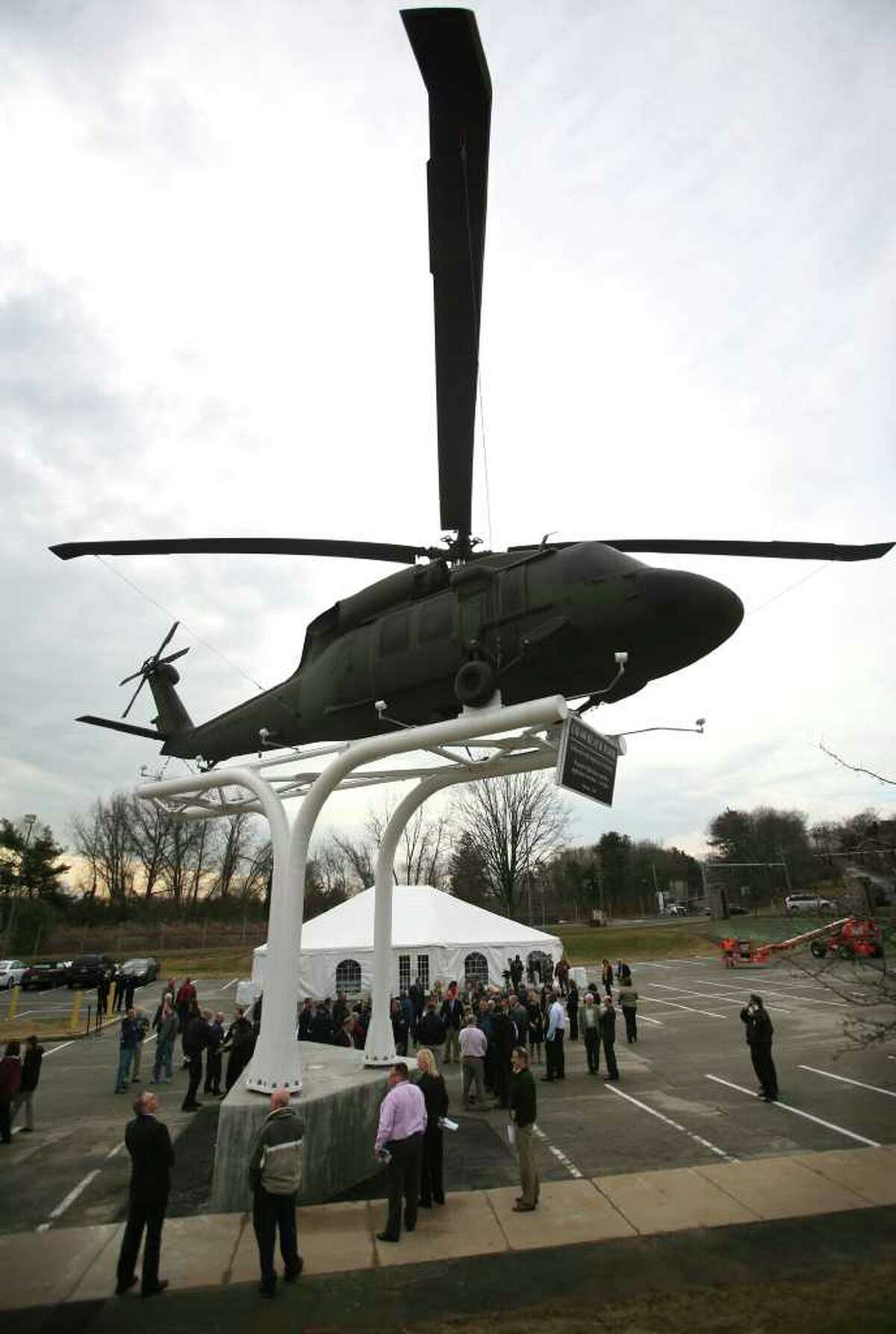 Sikorsky employees gather around the UH-60 Black Hawk helicopter unveiled in front of the company headquarters and factory on Main Street in Stratford on Wednesday, February 1, 2012.