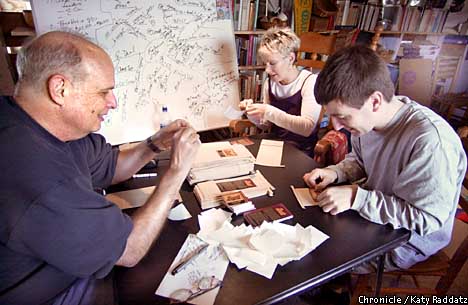 Lee Thorn with helpers Theresa Kingston and Damon Styer paste labels on coffee bags. Chronicle photo by Katy Raddatz