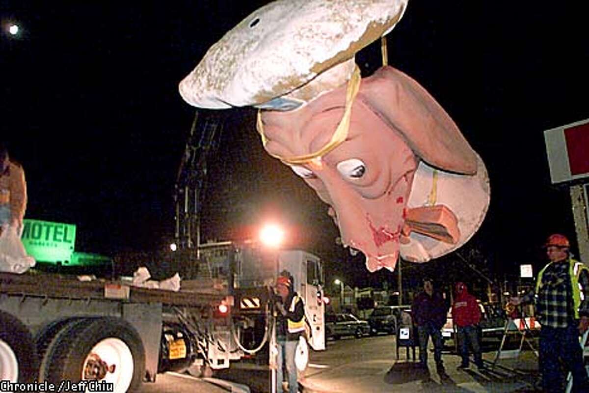 A Public Works crew lifted the damaged Doggie Diner head onto a truck after a strong wind knocked it down. Chronicle photo by Jeff Chiu