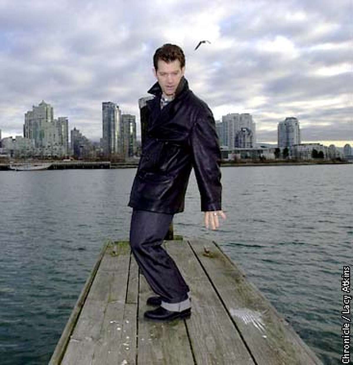 ISAAK-C-7FEB01-DD-LA Chris Isaak, stands on the dock, "This is the closes thing I get to surfing here", Isaak jokes as he pretends he's on a surfboard on the bay in Vancouver, Wed. Feb.7, 01. Photo By Lacy Atkins/San Francisco Chronicle