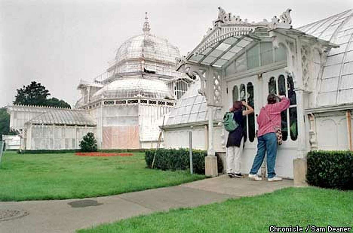 Izora Garcia de Lillard (left) and her mother Deborah Noland peek through the window at the Conservatory at Golden Gate Park Wednesday. Noland, visiting her daughter from Texas, expressed disappointment about not seeing the site. Sam Deaner/staff ALSO RAN 12/11/99