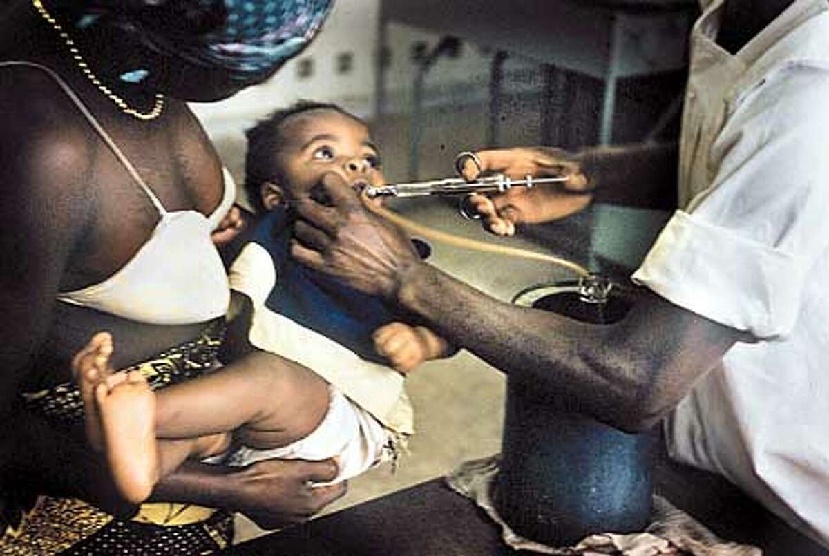 A girl receives an oral polio vaccine in Leopoldville (now Kinshasha) in 1958. Some say the vaccine might have been tainted with a virus that caused the AIDS epidemic. Photo courtesy of Henry Gelfund