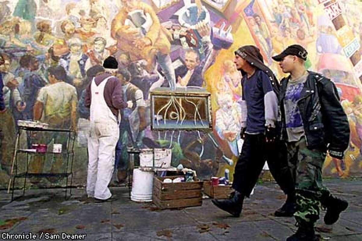 Osha Neumann, 59, (in white overalls) works on a restoration project on the landmark mural off Telegraph Avenue in Berkeley at Haste Street titled 'The People's History of Telegraph Avenue' originally painted by Neumann (and others) in 1976. (CHRONICLE PHOTO SAM DEANER)