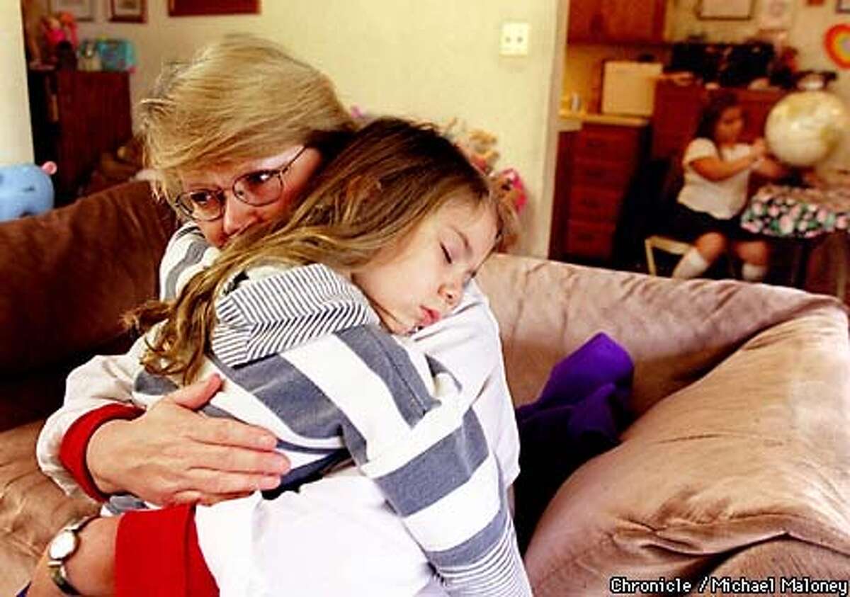 Sharon Nemeth Murch holds tightly to her sleeping daughter, Johnna Joy Murch who is almost five years old. In the kitchen is seven year old Ariel Murch. Ten years ago Sharon's daughter Michaela Garecht was kidnapped outside a Hayward store. BY MICHAEL MALONEY/THE CHRONICLE