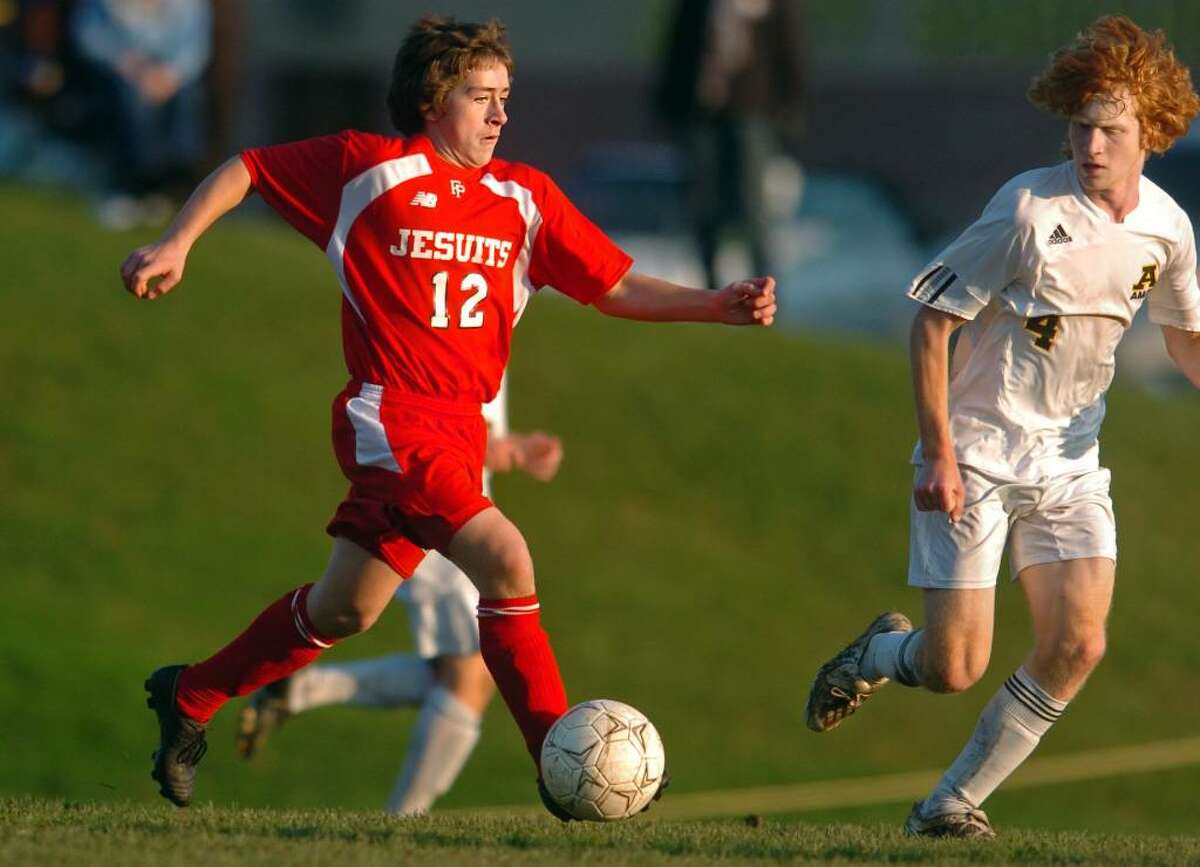 Fairfield Prep's David Bruton drives the ball down the field as Amity's Josh Brunwin defends during the second half of Tuesday's SCC semifinal game in Woodbridge.