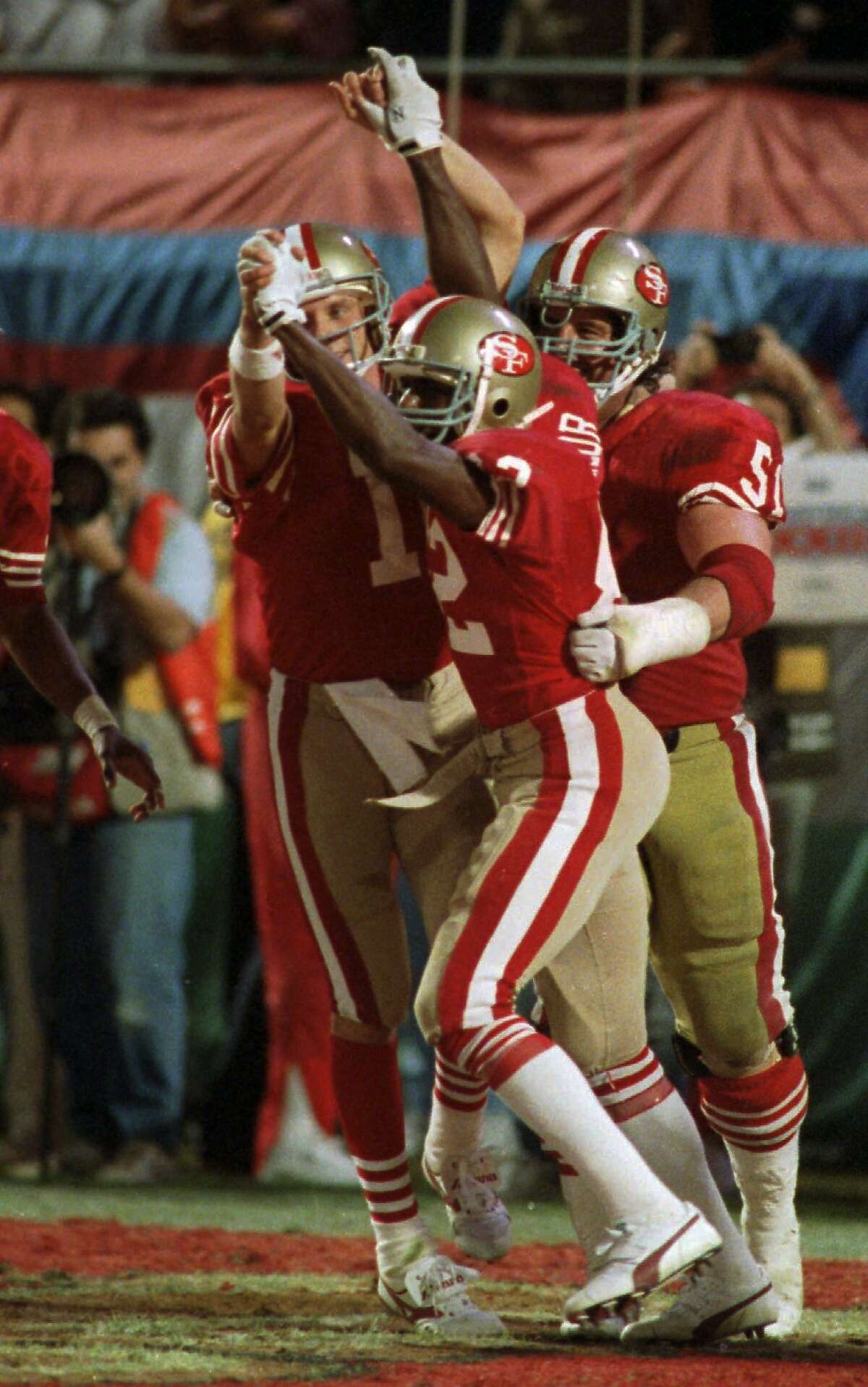 San Francisco 49ers quarterback Joe Montana (16) and wide receiver John Taylor (82) clasp hands after Montana's pass to Taylor at the end of the fourth quarter resulted in a 20-16 victory over the Cincinnati Bengals at Super Bowl XXIII Jan.22, 1989 in Miami. (AP Photo/Rusty Kennedy)