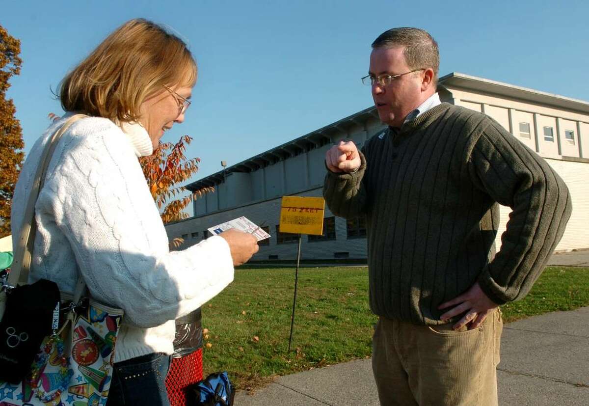Library supporters were on hand at Central High's polling place to greet voters as they make their way inside to vote, in Bridgeport, Conn. on Tuesday Nov. 4, 2009. Here, Bridgeport Council President Tom McCarthy, at right, tries to steer voter Peggie Dennehy to vote against the library issue.