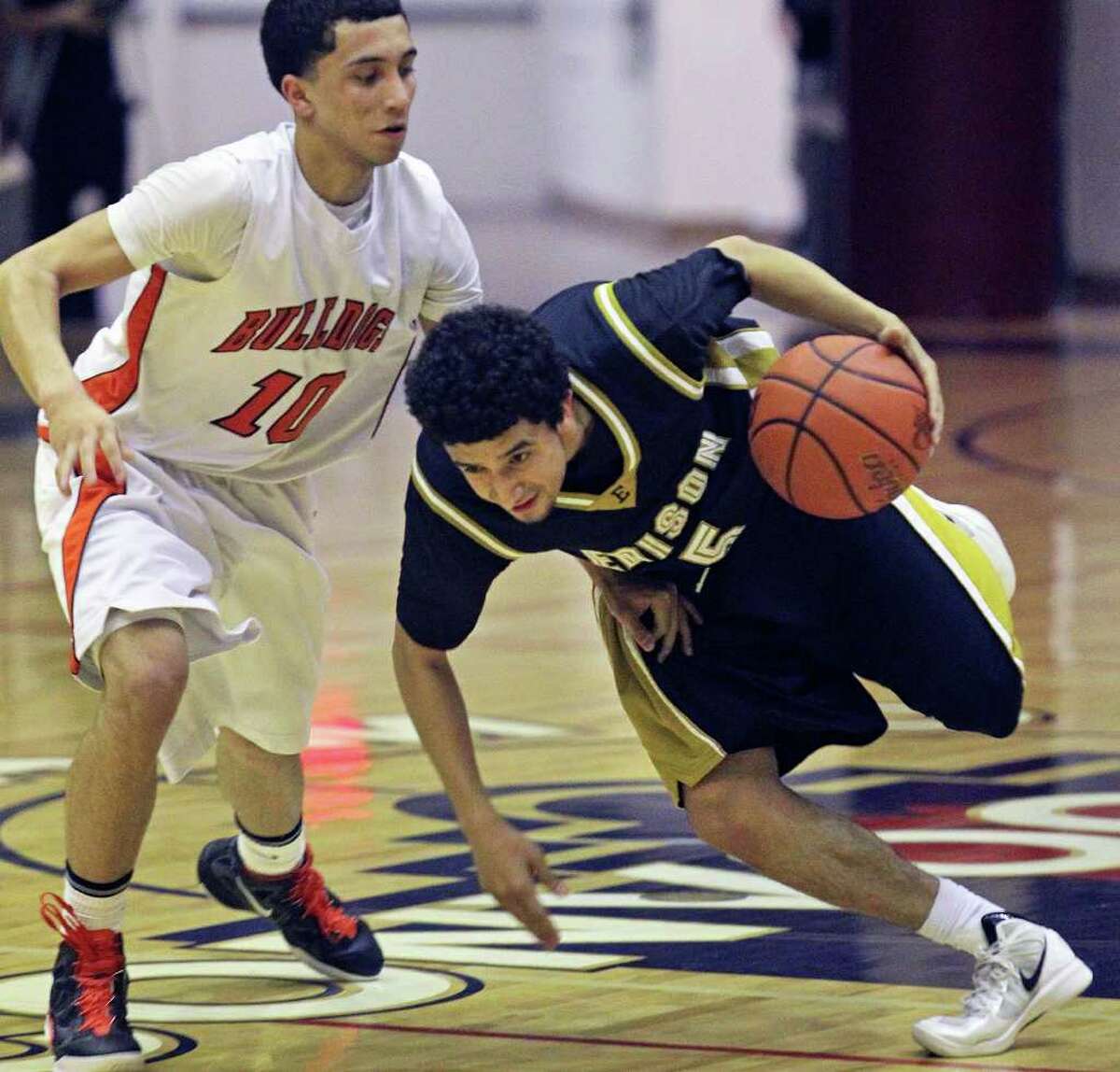 Edison's Artie Vela, who had 18 points, spins by Burbank's Jason Ainsworth on his way to the basket.