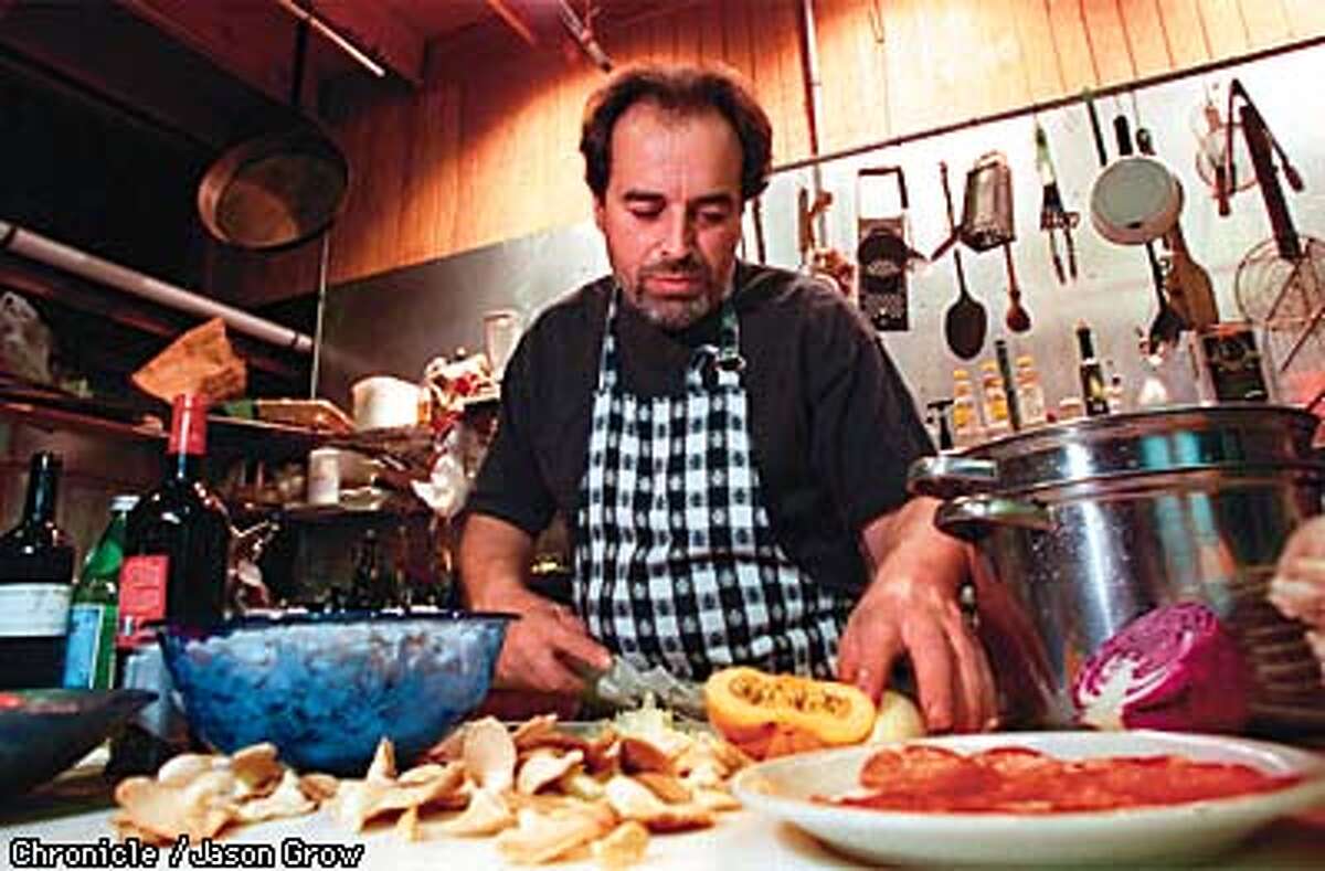 Angelo Garro slices oyster mushrooms for a pasta sauce. In the foreground is a plate of wild boar salami. CHRONICLE PHOTO BY JASON M. GROW
