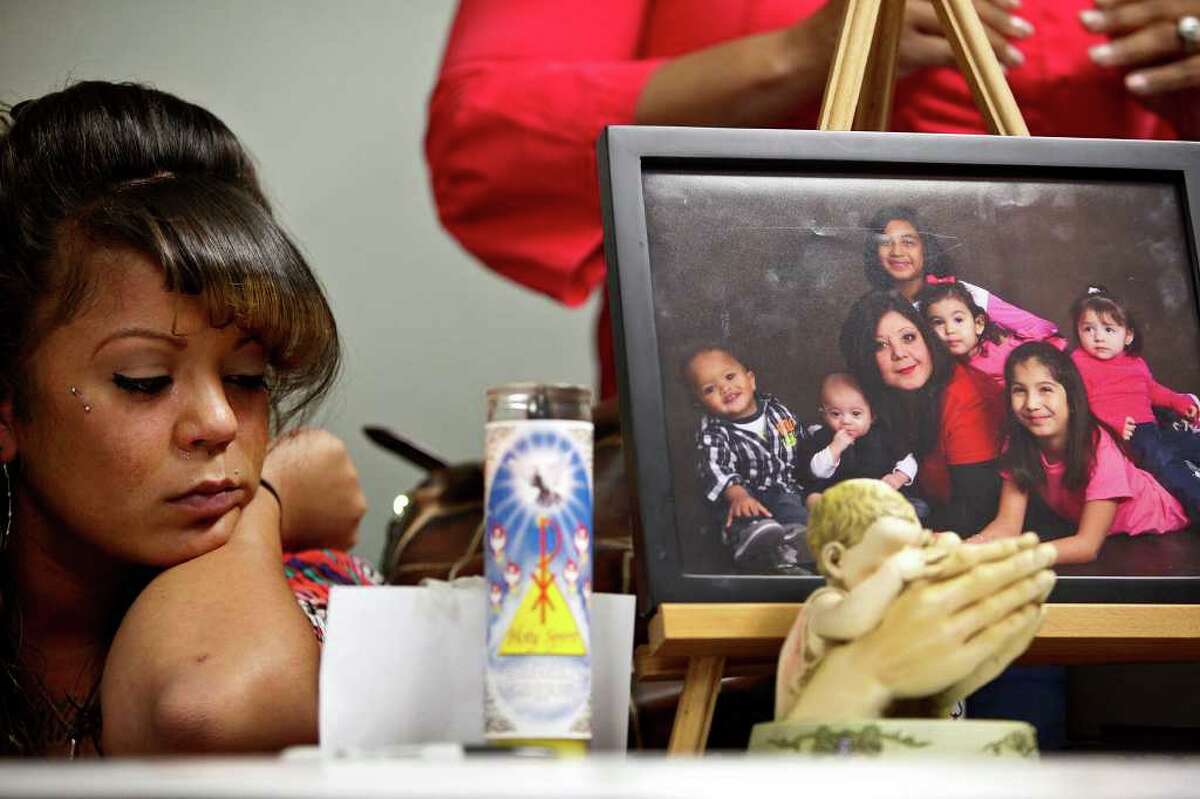 Sabrina Benitez, the mother of Joshua Davis Jr., sits next to a photograph of her mother, Natalie Vargas, with Vargas' daughter and grandchildren including Joshua (far left in photograph), just two weeks before he disappeared, during a event marking the one-year anniversary of his disappearance in New Braunfels at the Heidi Search Center in San Antonio on Saturday, Feb. 4, 2012.