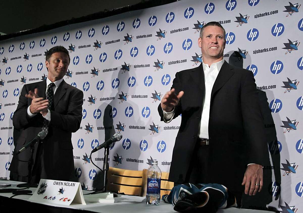 San Jose Sharks forward Owen Nolan, right, waves goodbye as general manager Doug Wilson, left, looks on during a news conference in San Jose, Calif., Tuesday, Feb. 7, 2012, announcing Nolan's retirement as a professional NHL hockey player.