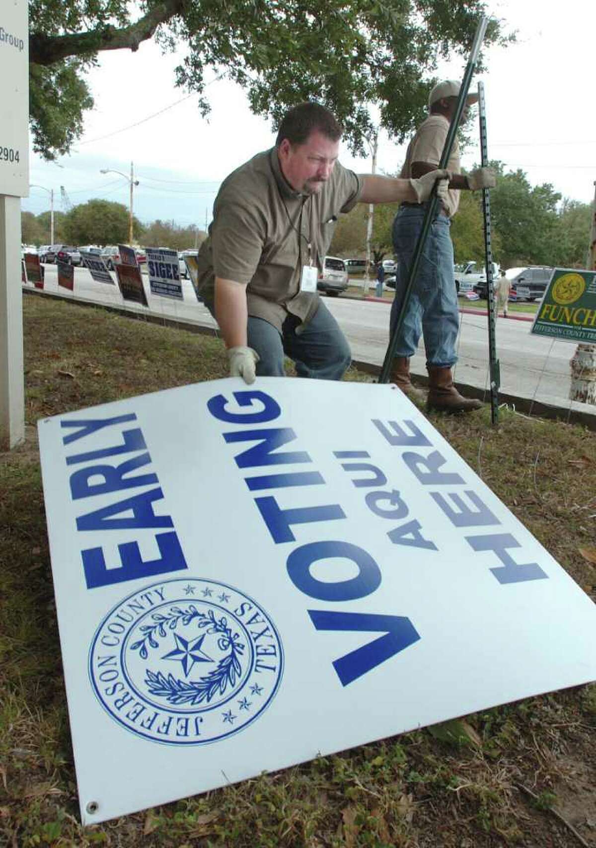 Jeff Courts, left, and Anthony Prevost with the Jefferson County Clerk's office remove an early voting sign from the lawn of the Jefferson County Courthouse in 2011. City and school elections this year are on May 12. Enterprise file art