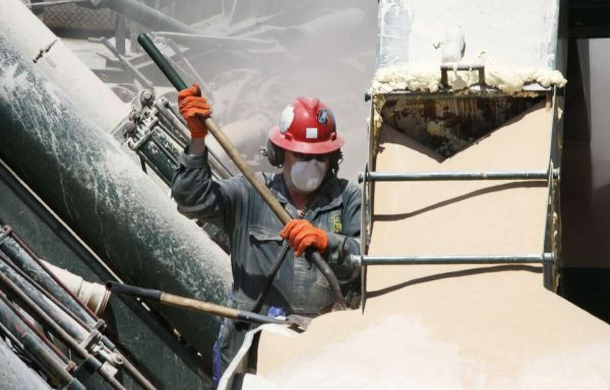 A worker shovels the powder used to make a mixture for hydraulic fracturing in Claysville, Pa., in 2011.