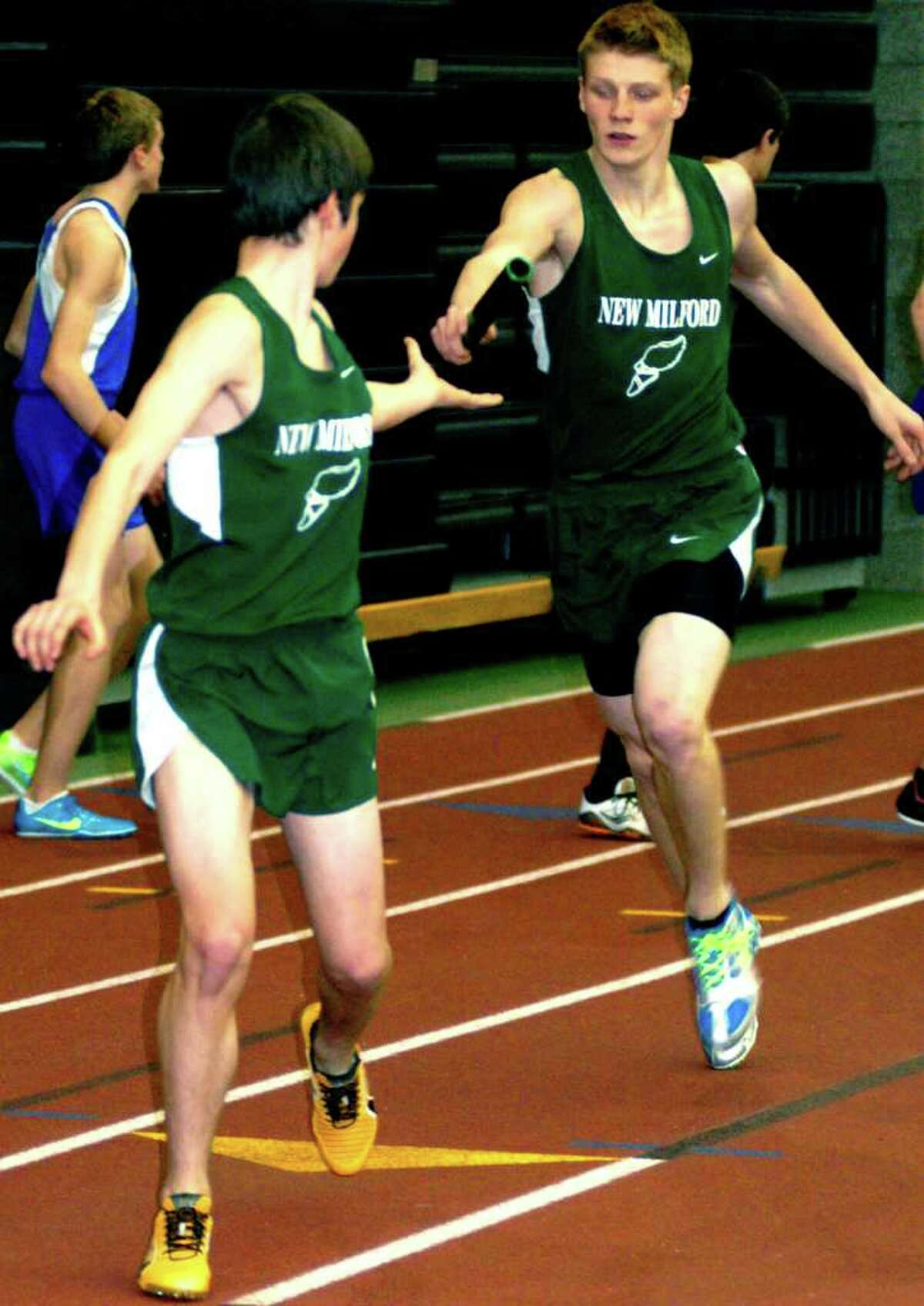 SPECTRUM/Donny Ek of the Green Wave hands off to a teammate en route to a fourth-place performance in the 1,600-meter sprint medley relay as New Milford High School's boys and girls' indoor track teams compete in the South-West Conference championship meet, Feb. 4, 2012 at the New Haven Athletic Center .
