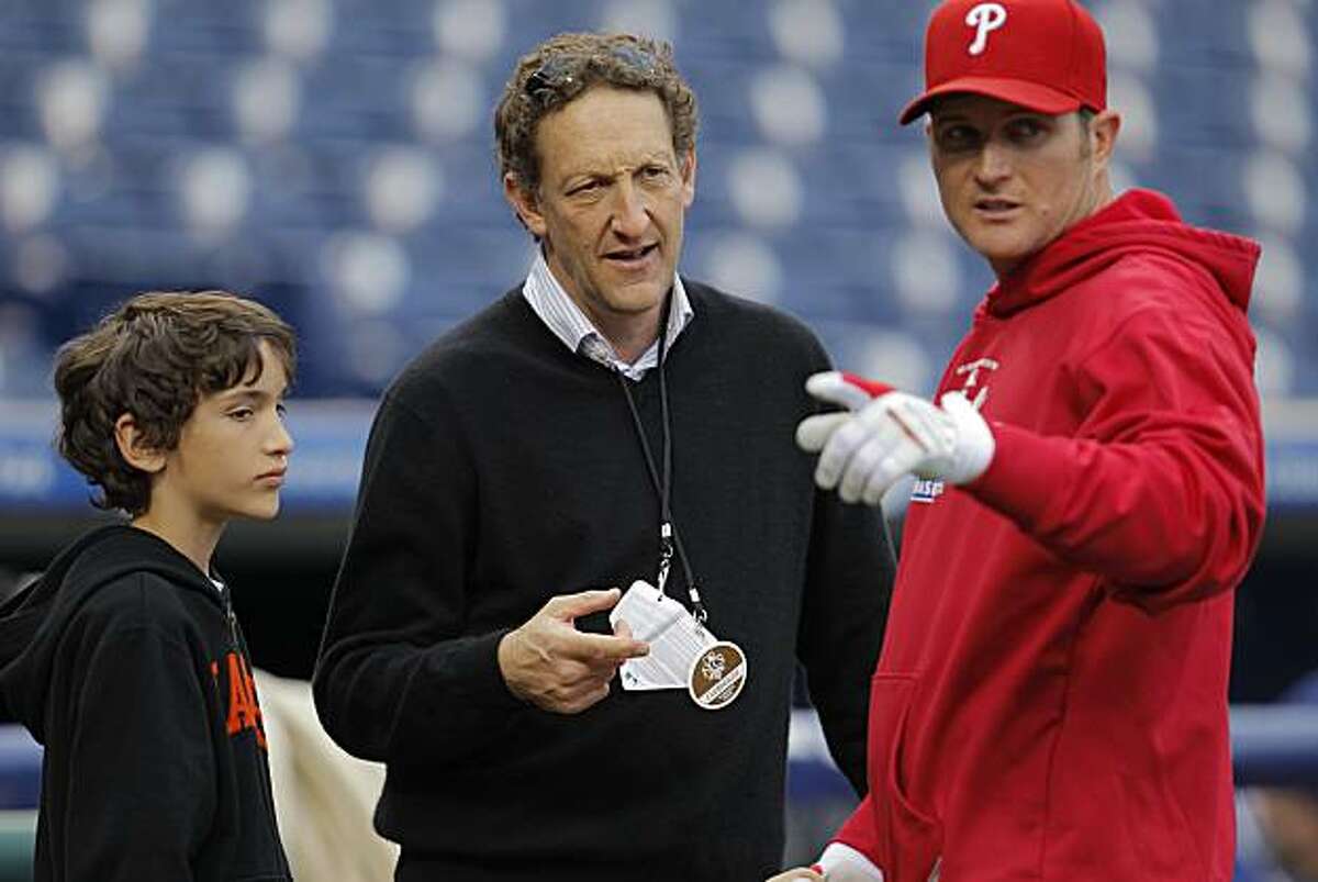 San Francisco Giants president Larry Baer, (center) along with his son Zach, talks with Phillies Mark Sweeney as the Phillies hold their final workouts, on Friday Oct. 15, 2010 at Citizens Bank Park, in Philadelphia, Penn., before the start of the National League Championship Series.