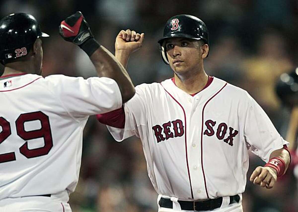 Boston Red Sox's Victor Martinez, right, celebrates with Adrian Beltre after scoring on a single by Kevin Youkilis in the eighth inning of a baseball game against the Oakland Athletics, Tuesday, June 1, 2010, in Boston. The Red Sox won 9-4.
